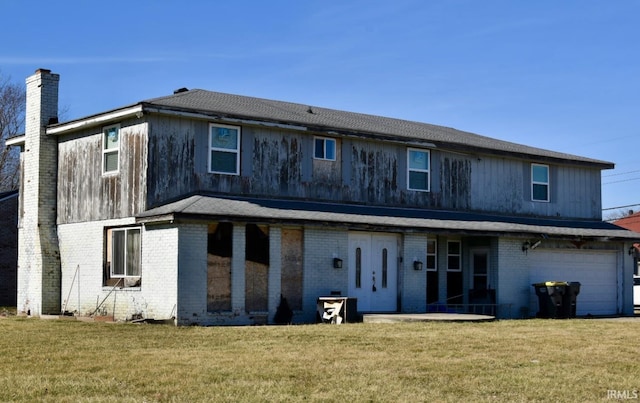 back of house featuring a garage and a yard