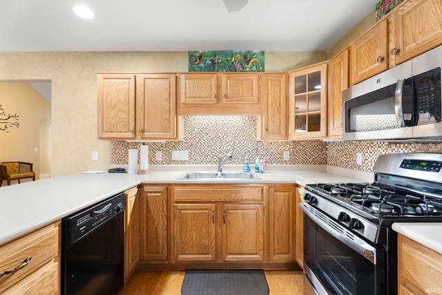 kitchen with light wood-type flooring, backsplash, sink, and stainless steel appliances