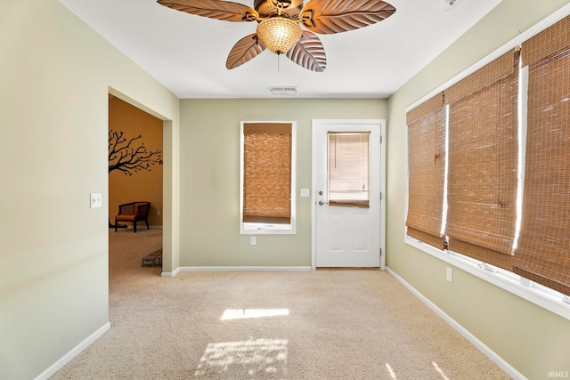 interior space with light carpet and ceiling fan