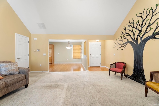 sitting room featuring light carpet and lofted ceiling