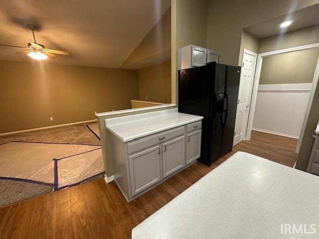 kitchen with white cabinets, lofted ceiling, dark wood-type flooring, black fridge with ice dispenser, and ceiling fan