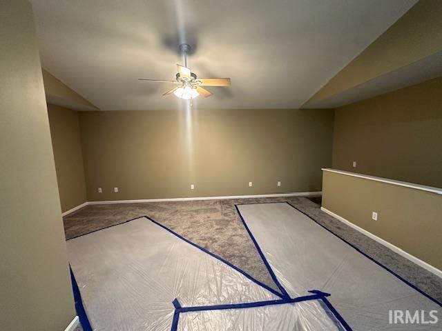 unfurnished room featuring carpet floors, vaulted ceiling, and ceiling fan