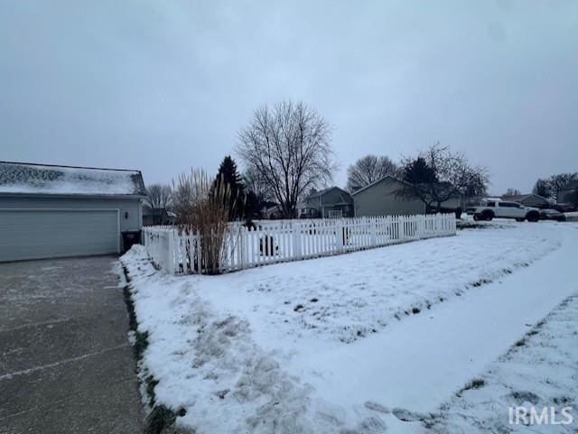 yard covered in snow featuring a garage