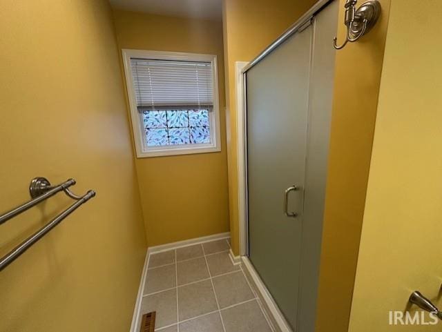 bathroom with tile patterned floors and a shower with door