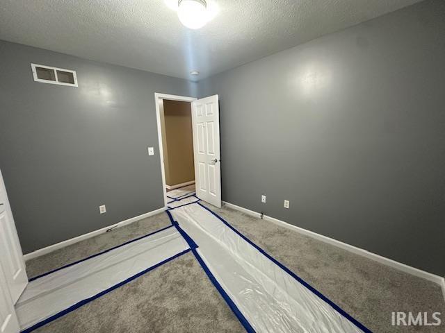 unfurnished bedroom featuring carpet and a textured ceiling