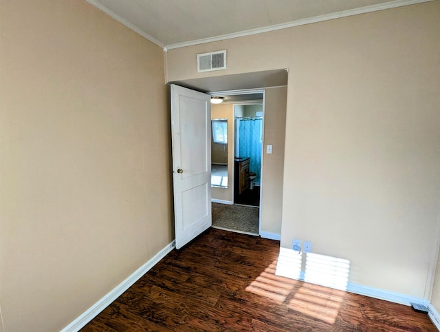 empty room featuring dark hardwood / wood-style flooring and crown molding