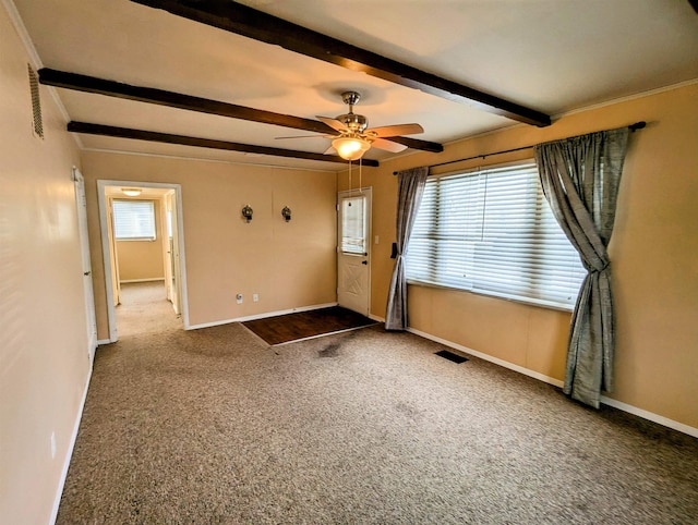 foyer with carpet, ceiling fan, plenty of natural light, and beamed ceiling