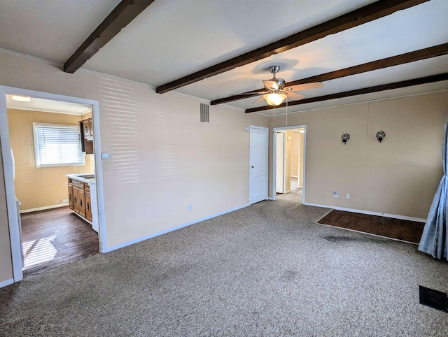 carpeted empty room featuring ceiling fan and beamed ceiling