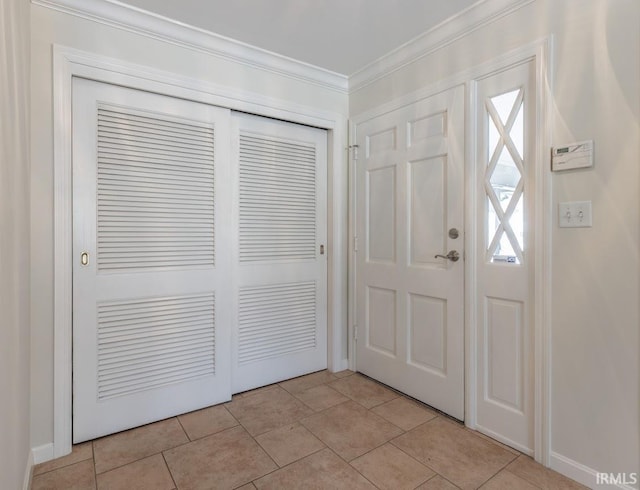 entryway with light tile patterned flooring and ornamental molding