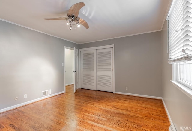 unfurnished bedroom with ceiling fan, a closet, crown molding, and light hardwood / wood-style floors