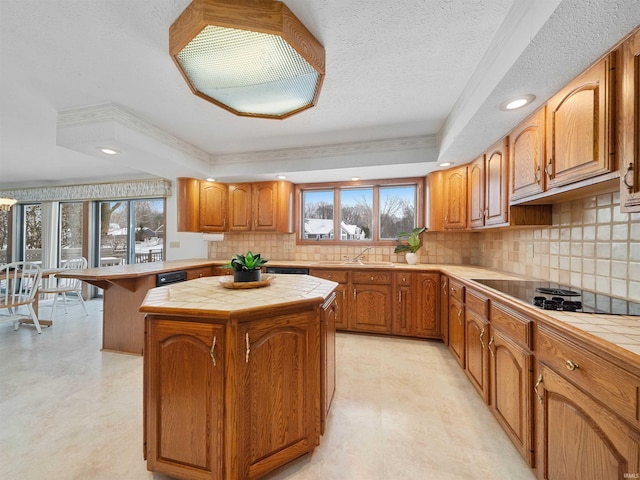 kitchen with a wealth of natural light, tile countertops, black electric cooktop, and a center island