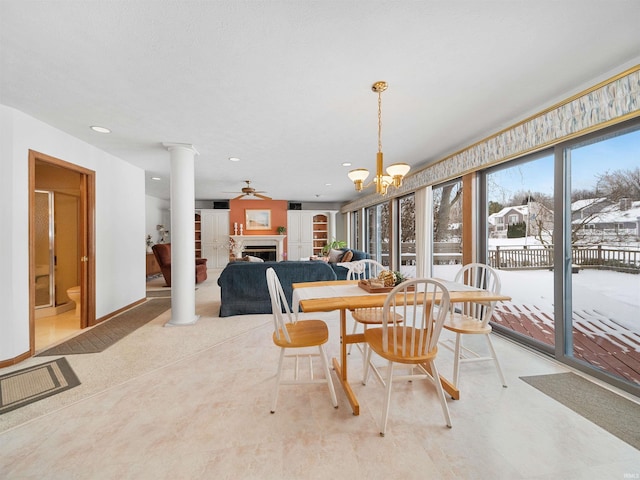 dining room featuring ceiling fan with notable chandelier and decorative columns