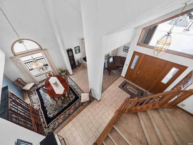 entryway with a high ceiling and carpet flooring