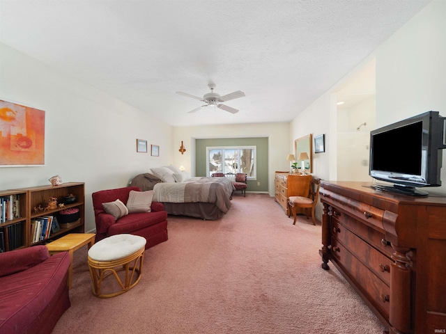 bedroom with ceiling fan, light colored carpet, and a textured ceiling