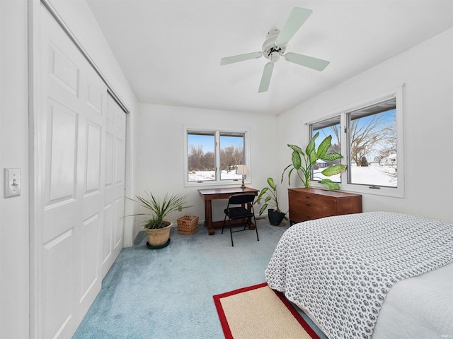 carpeted bedroom with ceiling fan and a closet