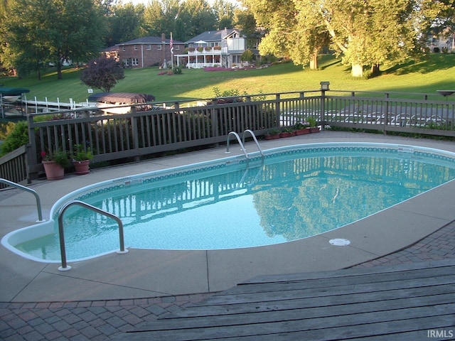 view of swimming pool with a yard