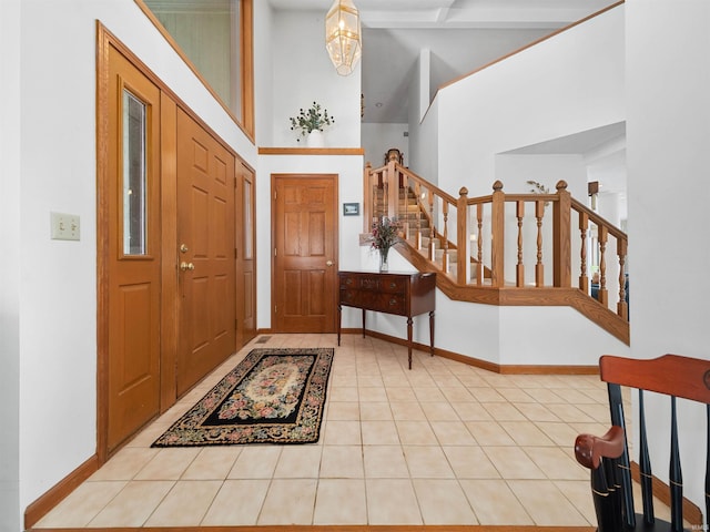 tiled foyer entrance with a towering ceiling and a notable chandelier