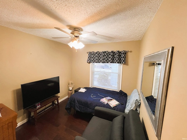 bedroom with a textured ceiling, ceiling fan, and dark hardwood / wood-style flooring