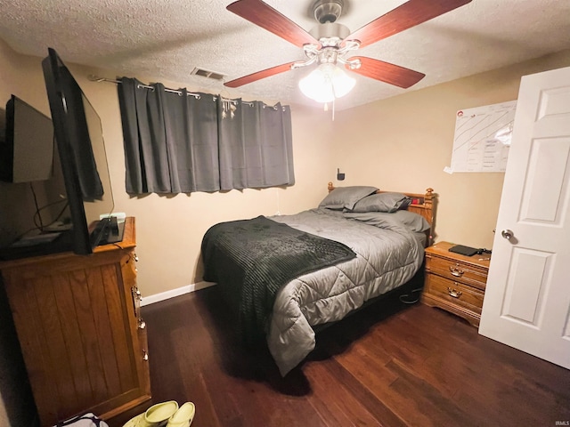 bedroom with ceiling fan, a textured ceiling, and dark hardwood / wood-style flooring