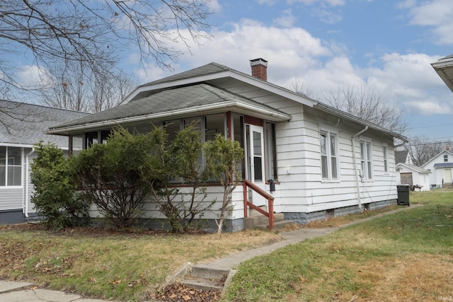 view of home's exterior with a lawn and a chimney