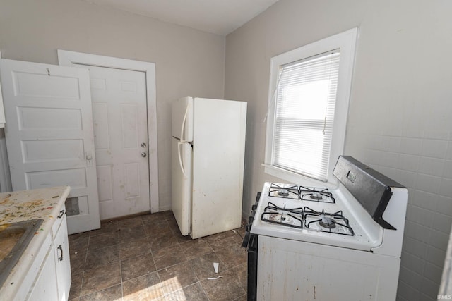 kitchen featuring light countertops, white appliances, and white cabinets