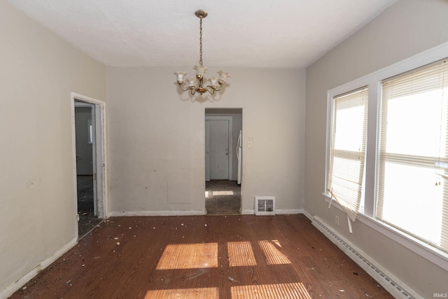 unfurnished dining area featuring dark wood finished floors, a notable chandelier, visible vents, a baseboard heating unit, and baseboards