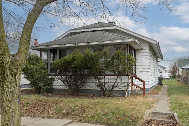 view of side of home with a yard and a sunroom