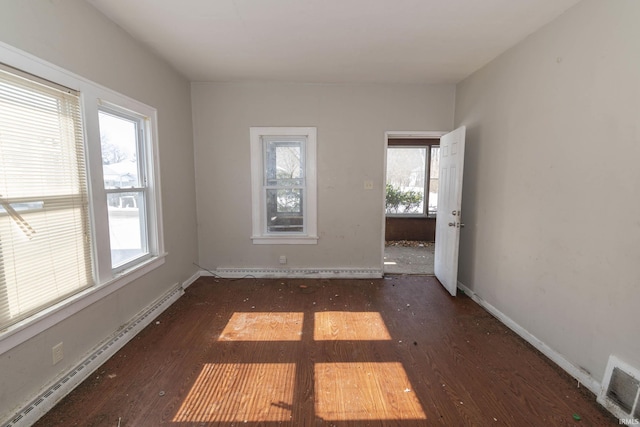 unfurnished room featuring a baseboard radiator, a baseboard heating unit, dark wood-type flooring, visible vents, and baseboards