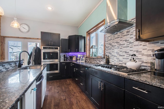 kitchen with ventilation hood, stainless steel appliances, stone countertops, hanging light fixtures, and sink