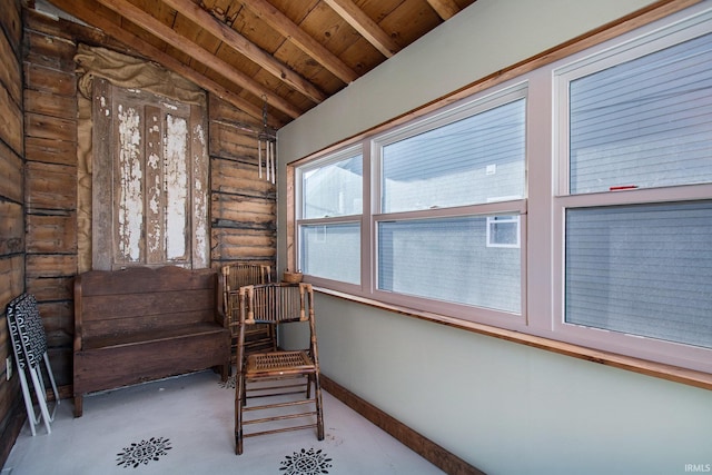 unfurnished sunroom featuring lofted ceiling with beams and wooden ceiling