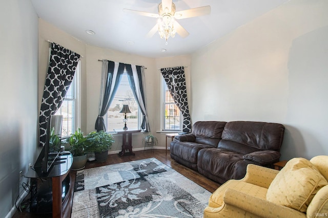 living room with ceiling fan and dark wood-type flooring