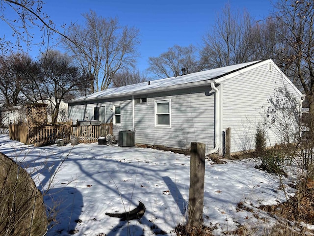 snow covered back of property featuring a deck and cooling unit