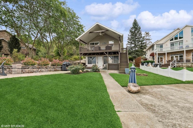 view of front of home featuring ceiling fan, a balcony, a wooden deck, and a front yard