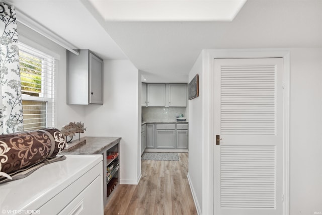 kitchen featuring decorative backsplash, gray cabinets, and light wood-type flooring