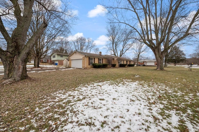 snowy yard featuring a garage