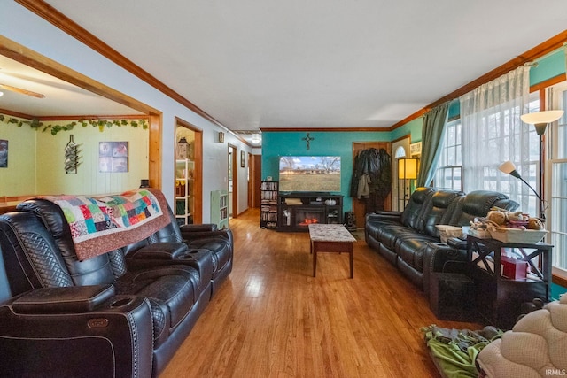 living room featuring a fireplace, crown molding, and hardwood / wood-style floors