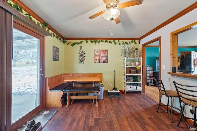 dining area with ceiling fan, dark hardwood / wood-style floors, and ornamental molding