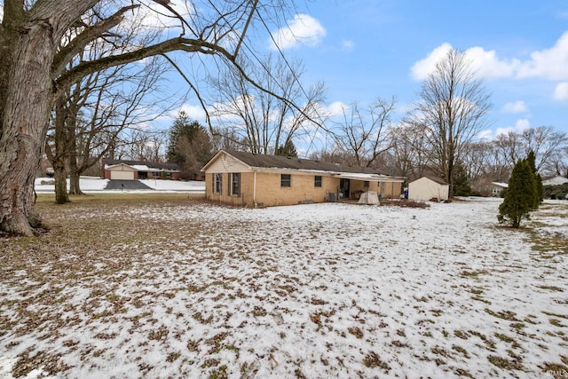 view of snow covered back of property