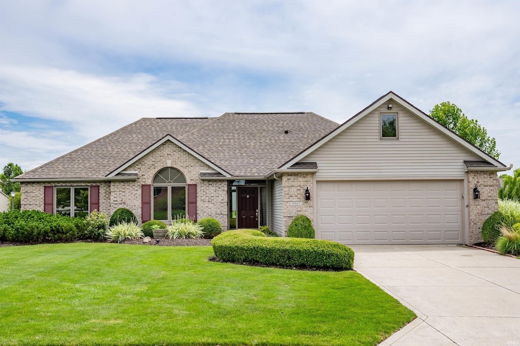 ranch-style home with a front lawn and a garage