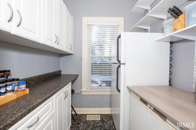 kitchen with white cabinetry and white refrigerator