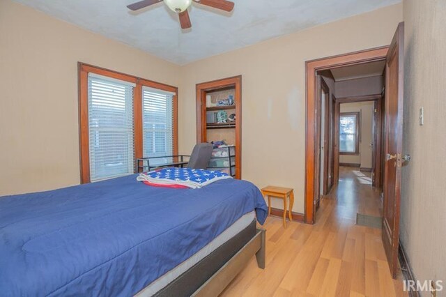 bedroom featuring light wood-type flooring, ceiling fan, and multiple windows