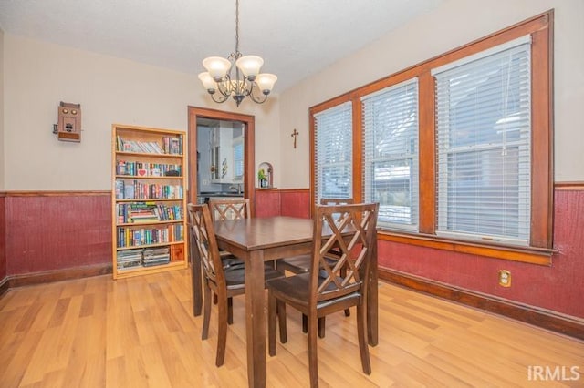 dining room with light wood-type flooring and a chandelier