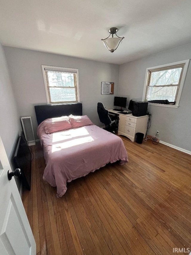 bedroom featuring multiple windows and light hardwood / wood-style flooring