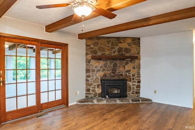 unfurnished living room featuring ceiling fan, hardwood / wood-style flooring, and beamed ceiling