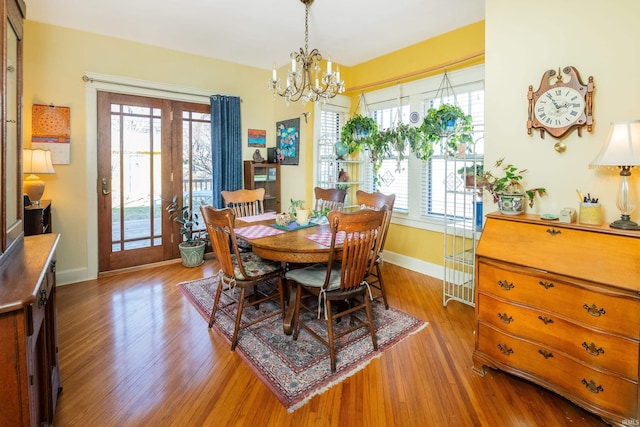 dining space featuring an inviting chandelier and light hardwood / wood-style flooring