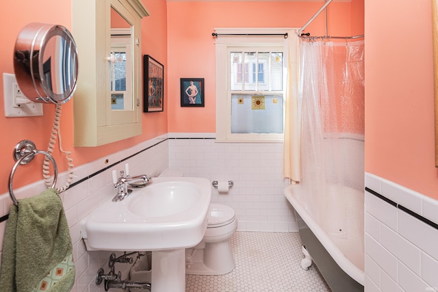 full bathroom with shower / bathtub combination with curtain, tile patterned flooring, sink, tile walls, and toilet