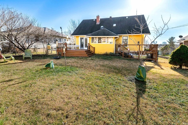 back of house with a lawn, french doors, and a deck