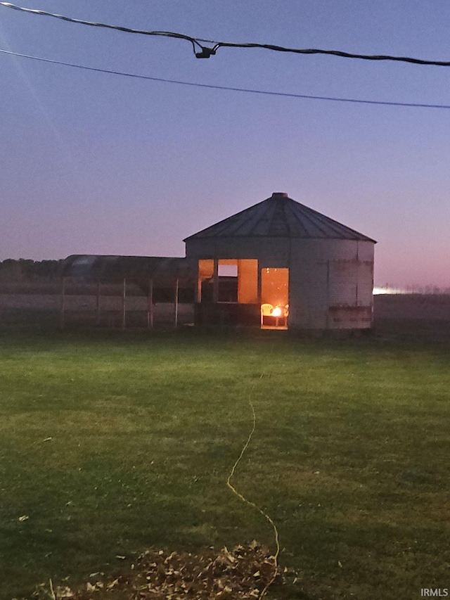 back house at dusk with a lawn