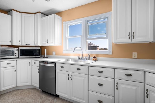 kitchen with a textured ceiling, sink, stainless steel appliances, and white cabinetry