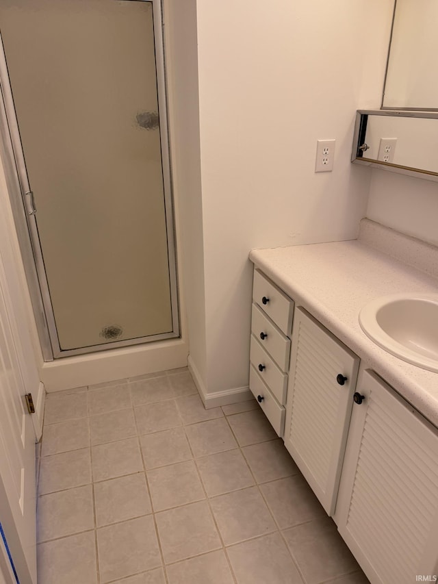 bathroom featuring tile patterned flooring, a shower with door, and vanity